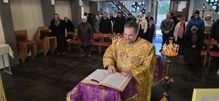 Der Priester liest aus dem geöffneten Evangelium, die Gemeinde steht